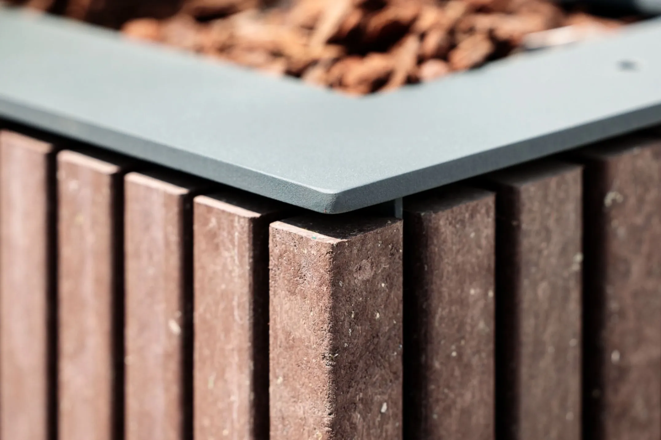 Detalhe de floreira Floema da linha Frame, com estrutura em aço metalizado e pintado e plástico reciclado castanho. 