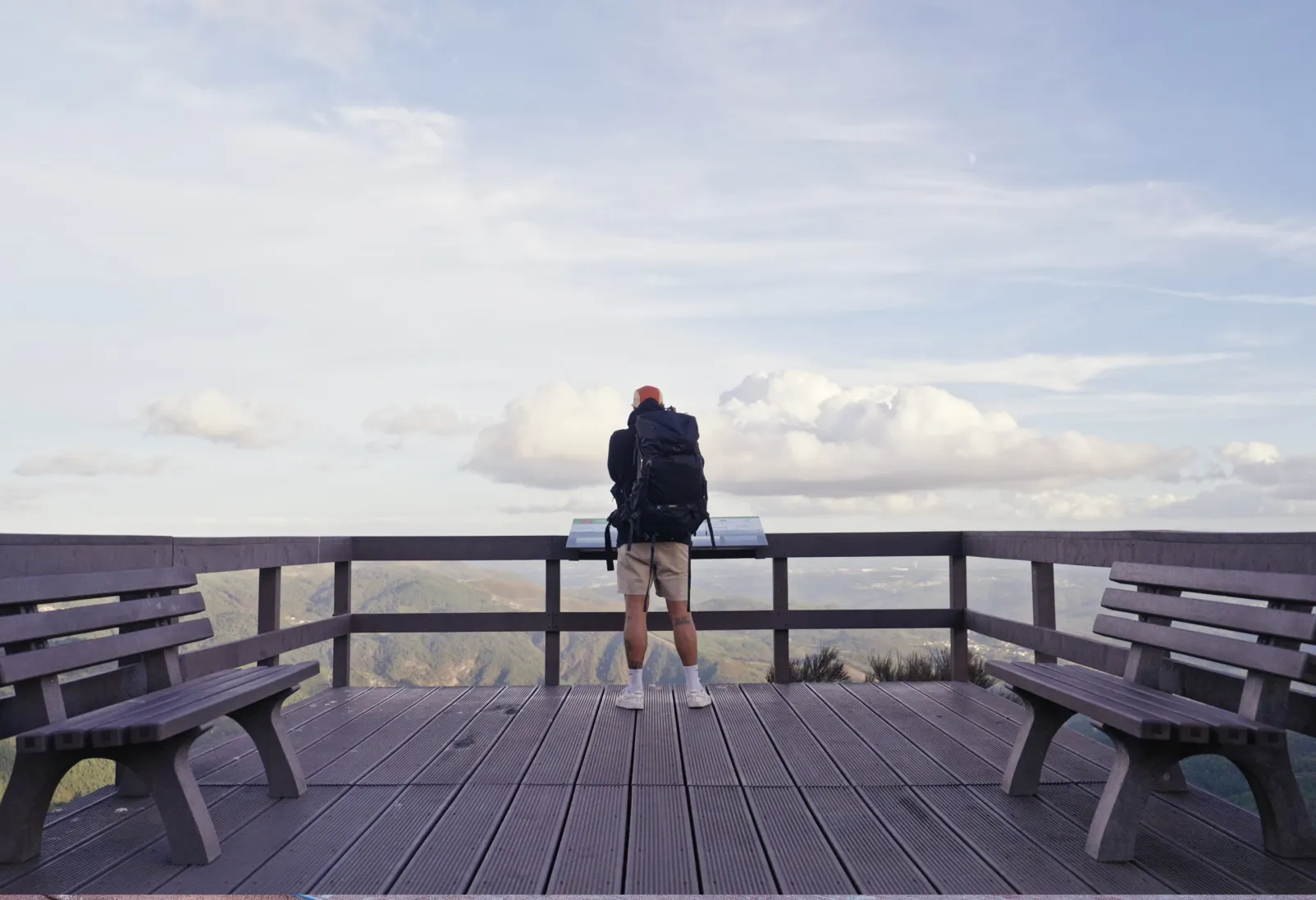Caminhante em miradouro de plástico reciclado a ler conteúdo de mesa interpretativa com painel em HPL Print.