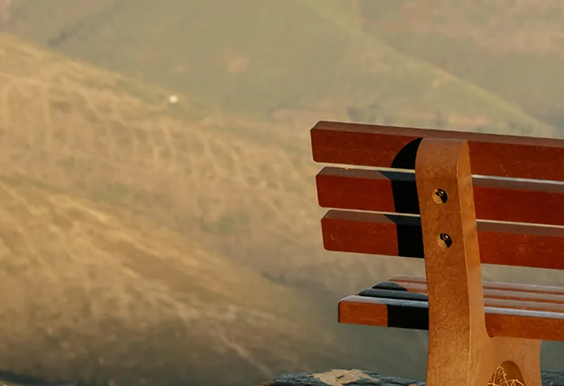 Detalhe de banco em plástico reciclado castanho Floema em espaço natural.