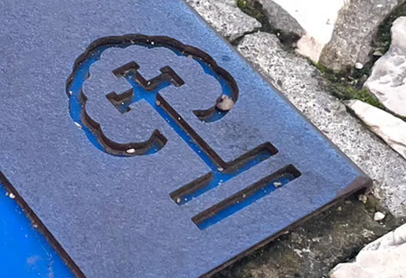 Detalhe de informação vazada em marca de pavimento de rotas religiosas, caminho de fátima em aço e com placa de HPL de cor, instalada em calçada.