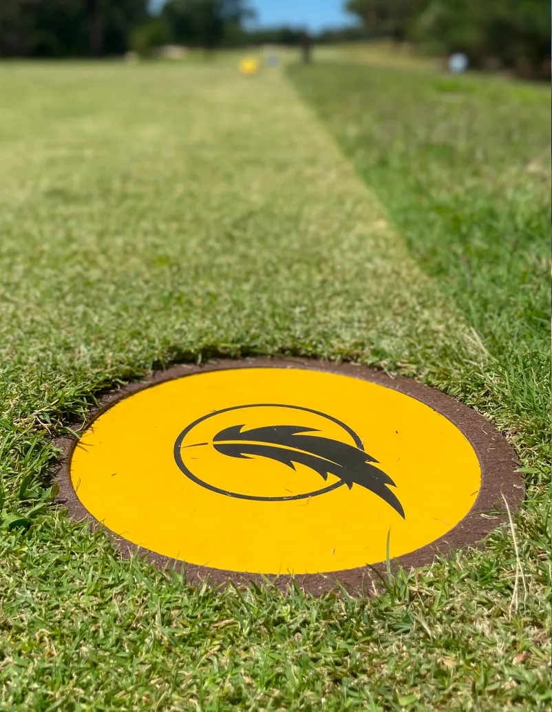 Detalhe de disc marker em área de tee de campo de golfe.