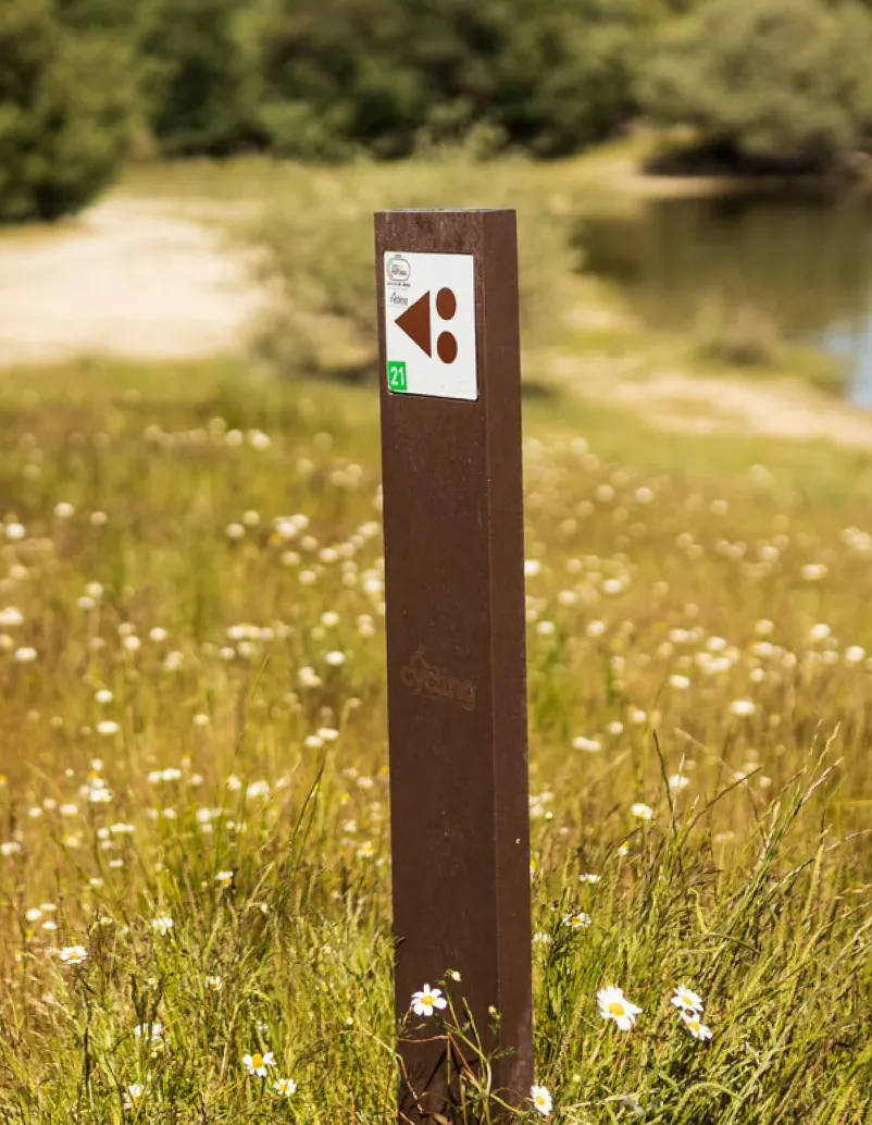 Thin recycled plastic marker with embedded aluminium sign, in a natural setting.
