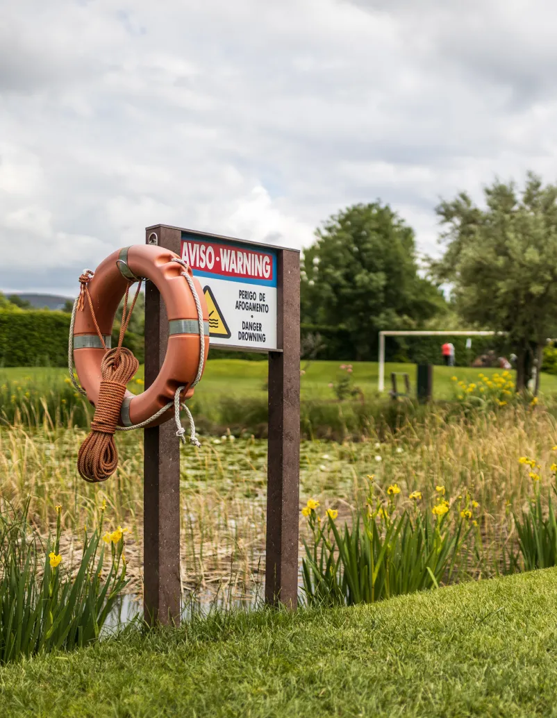 Painel informativo de campo de golfe com estrutura em plástico reciclado castanho e com suporte e bóia salva-vidas.