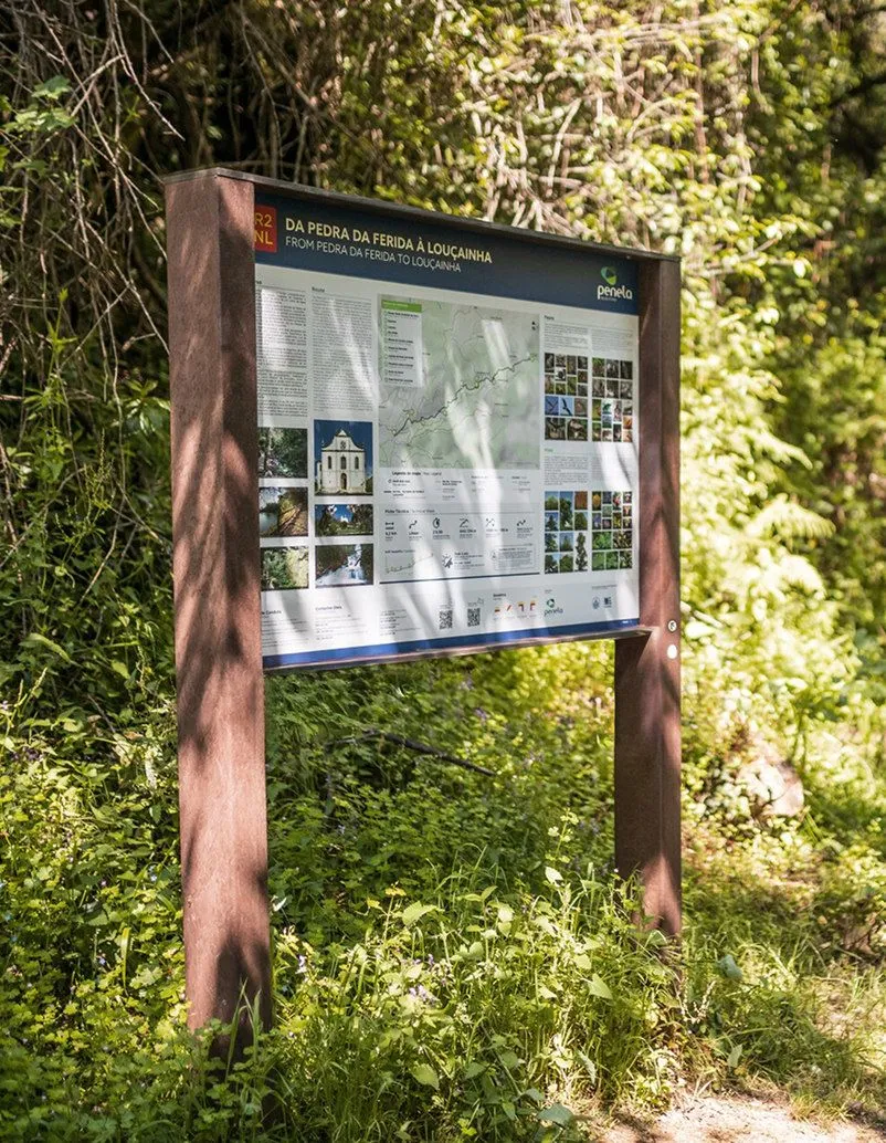 Large Floema information panel, with brown recycled plastic frame, in a natural green area.