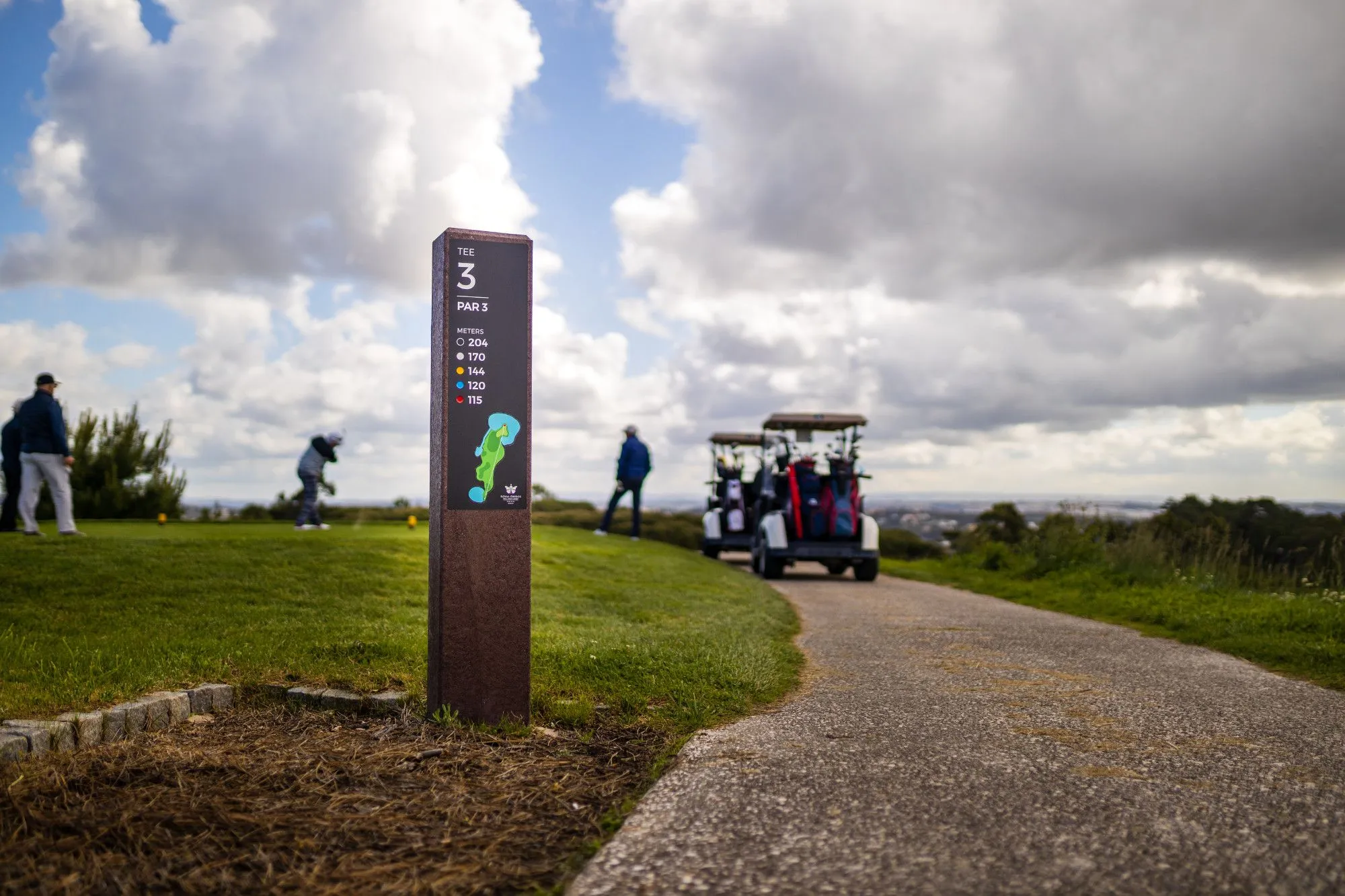 Tee totem royal for tee areas with structure in recycled plastic, with golfers on the background.